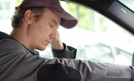 a driver asleep while holding the steering wheel